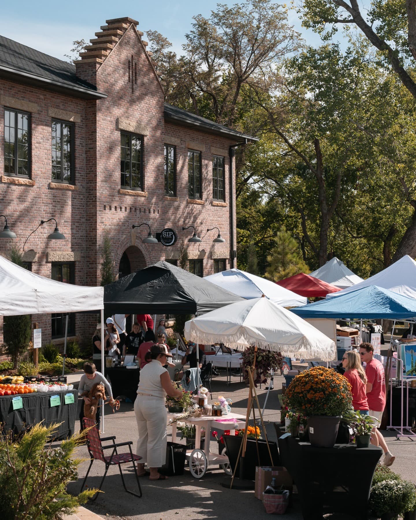 Selah's brick gabled storefront in Norman, with a Saturday farmers market filling the street